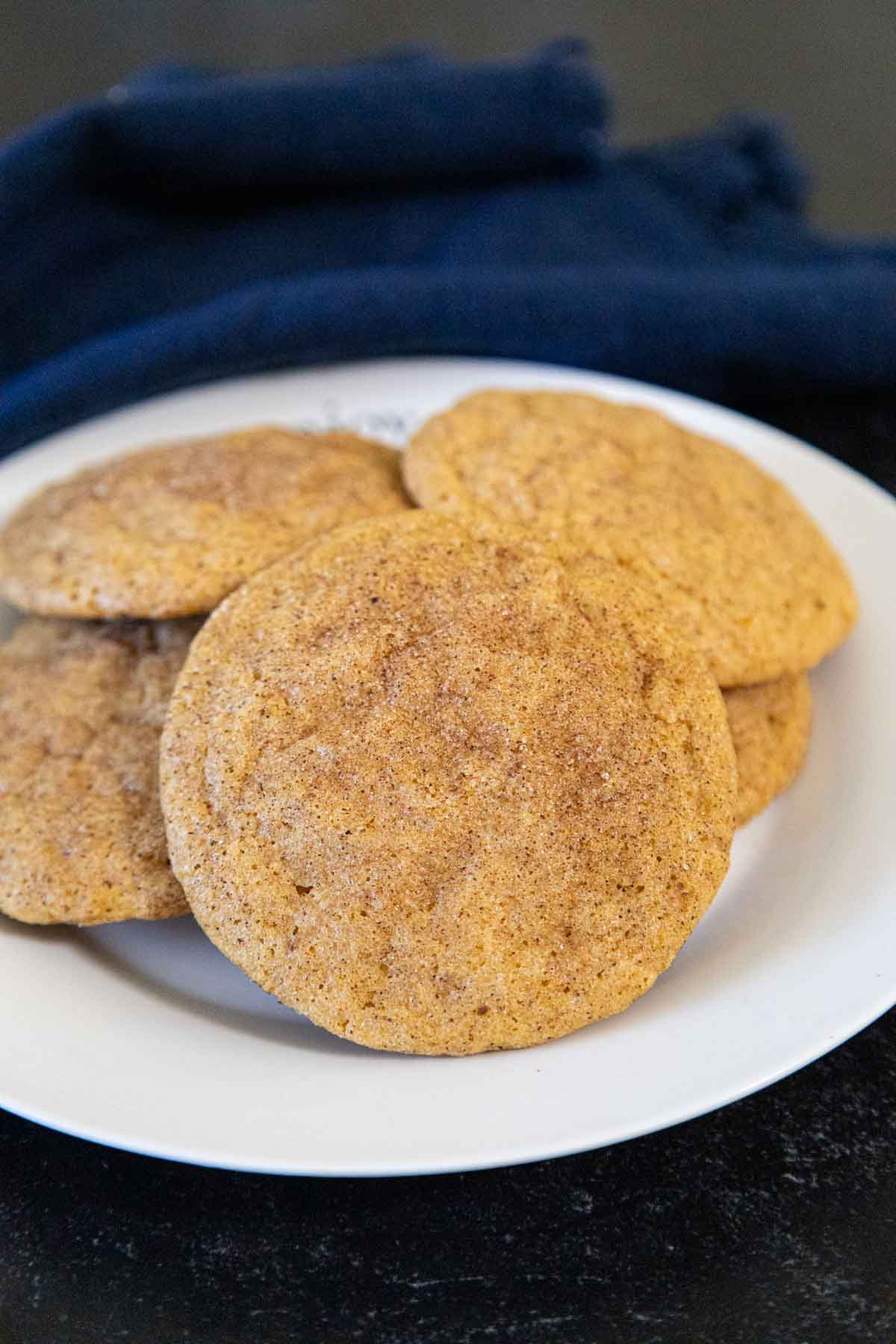 Plate of soft and chewy pumpkin snickerdoodle cookies with a cinnamon sugar coating.