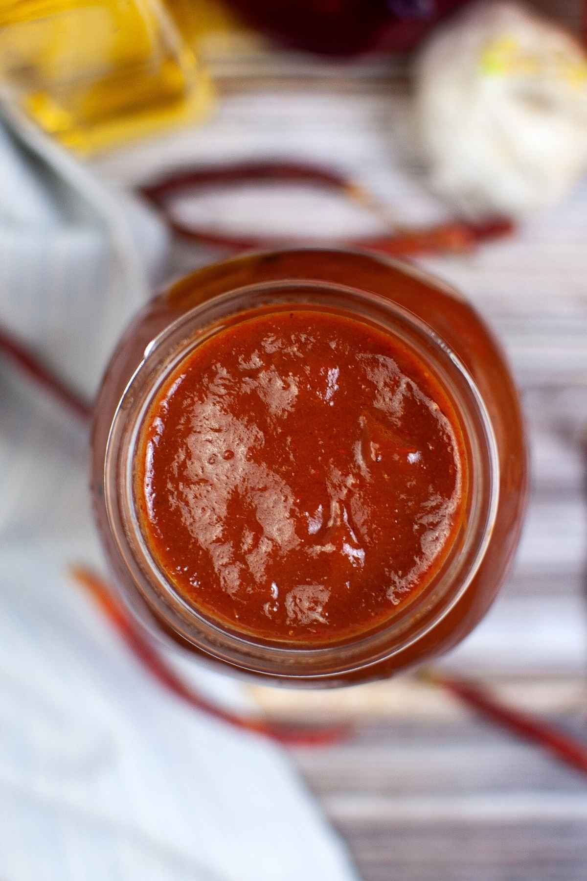 Overhead view of a jar filled with red sauce.