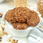 A stack of homemade Star Crunch cookies made with chocolate, marshmallows, and crispy rice cereal, displayed on a white pedestal stand.