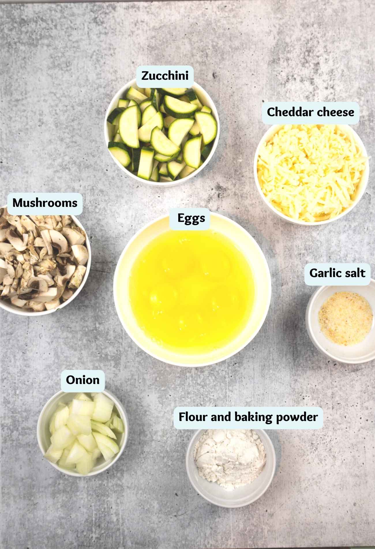 Ingredients for quiche recipe to include: zucchini, eggs, cheddar cheese, garlic salt, mushrooms, onion, flour, and baking powder.