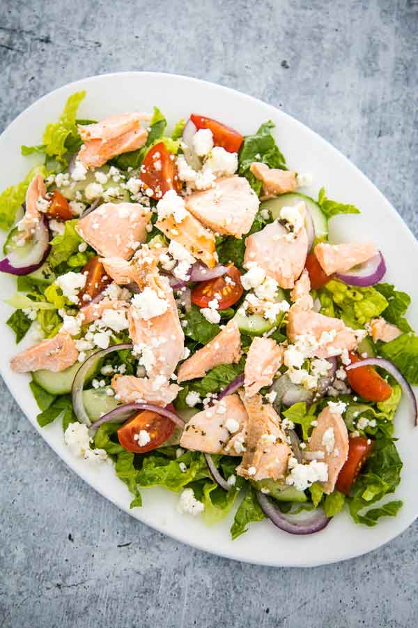 Overhead view of Greek Salmon Salad with feta cheese, red onion, cucumbers, and tomatoes.