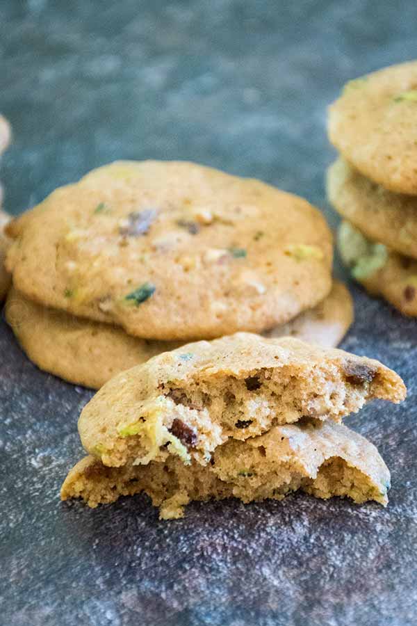 Close up of a zucchini spice cookie broken in half, revealing a soft and moist interior.