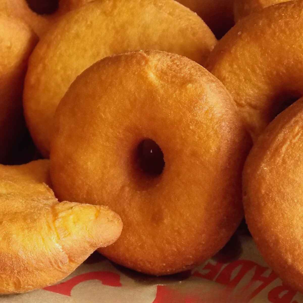 Freshly fried yeast donuts cooling before glazing.