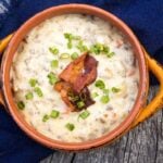 Overhead image of a bowl of creamy cheeseburger soup topped with crispy bacon pieces and chopped green onions.