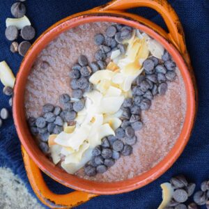 Overhead view of chocolate chia pudding garnished with chocolate chips and coconut flakes.