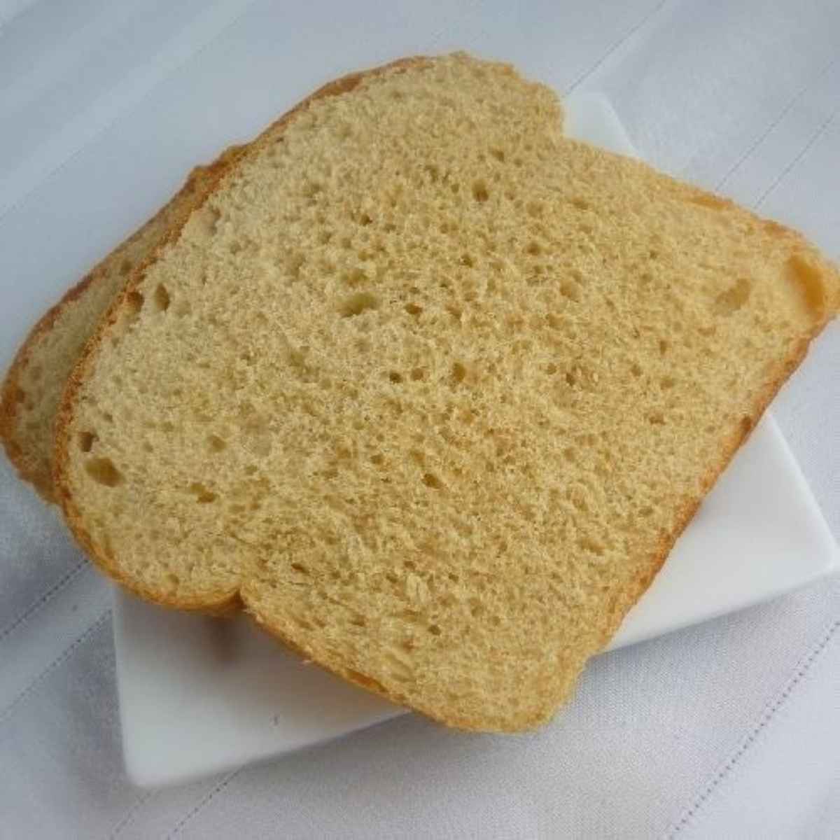 Two slices of bread on a white plate.