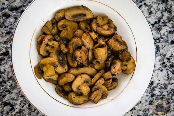 Umami mushrooms served in a white bowl with a gold rim.