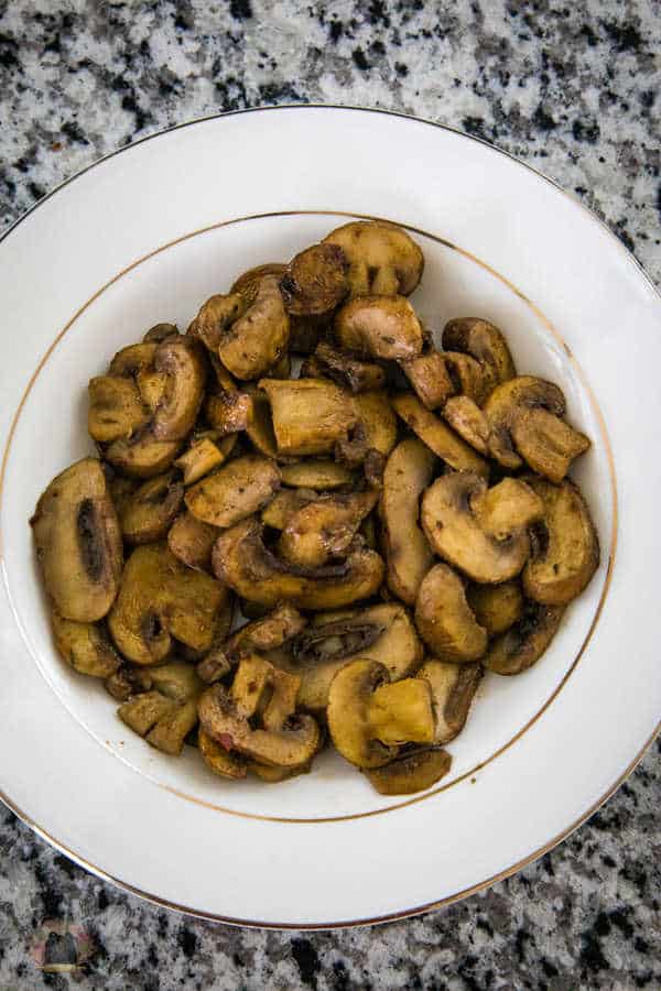 Umami mushrooms served in a white bowl with a gold rim.