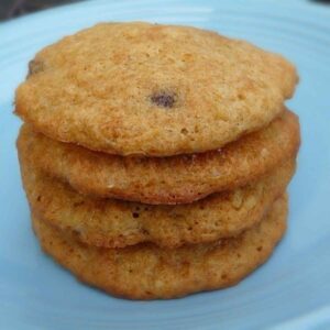 A stack of 4 banana chocolate chip cookies on a blue plate.