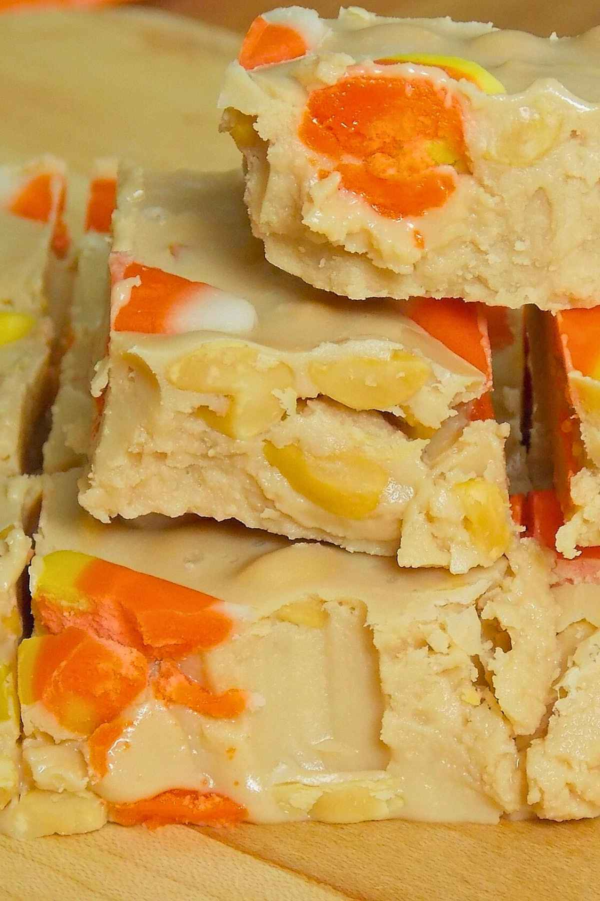 Close up of stacked fudge squares showing candy corn pieces embedded inside and a smooth, creamy texture.