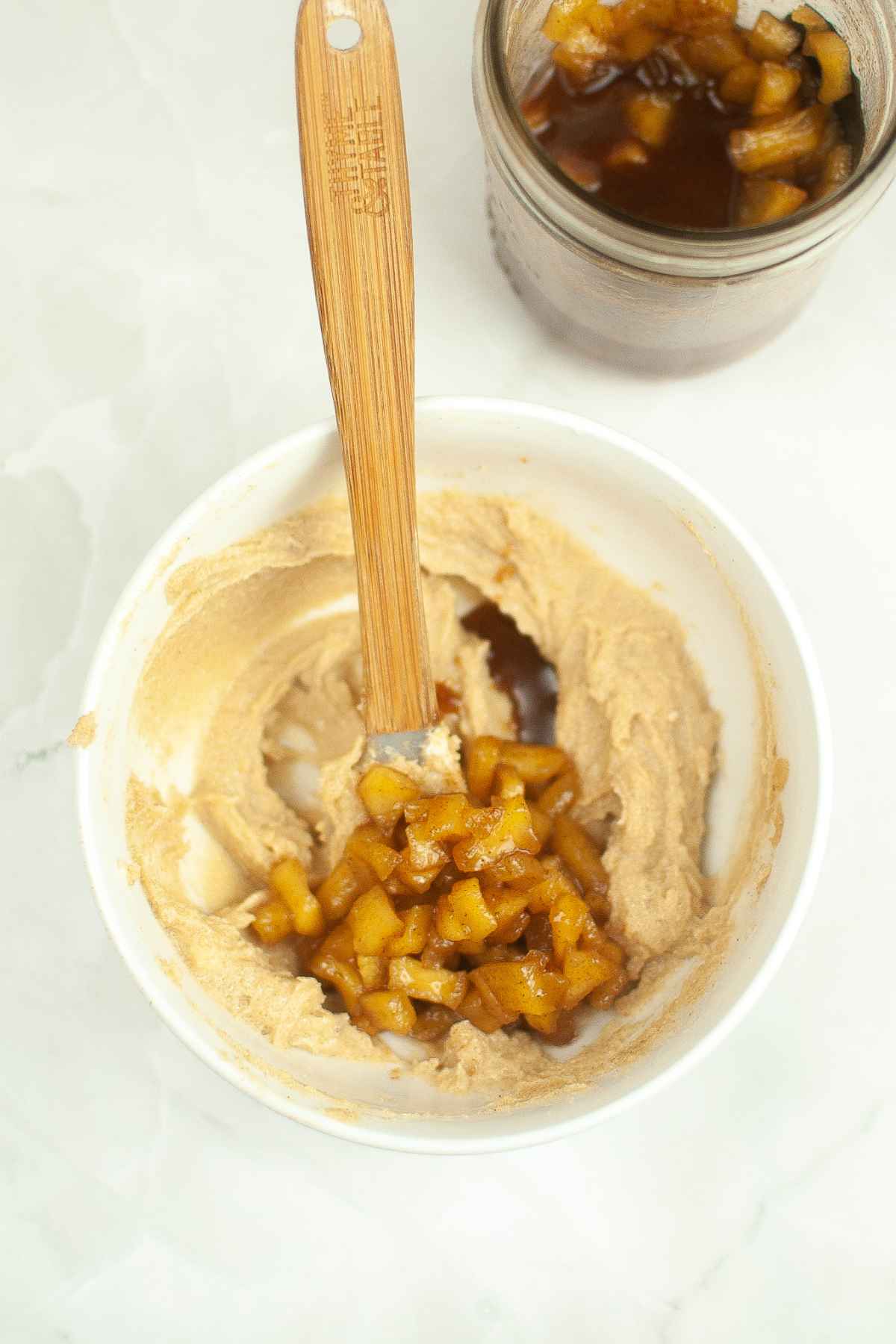 A bowl of apple pie topping and brown sugar butter being mixed together.