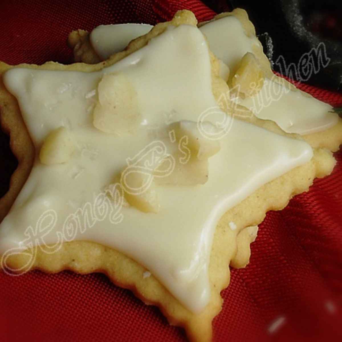 Two star shaped eggnog cut-out cookies on a red background.