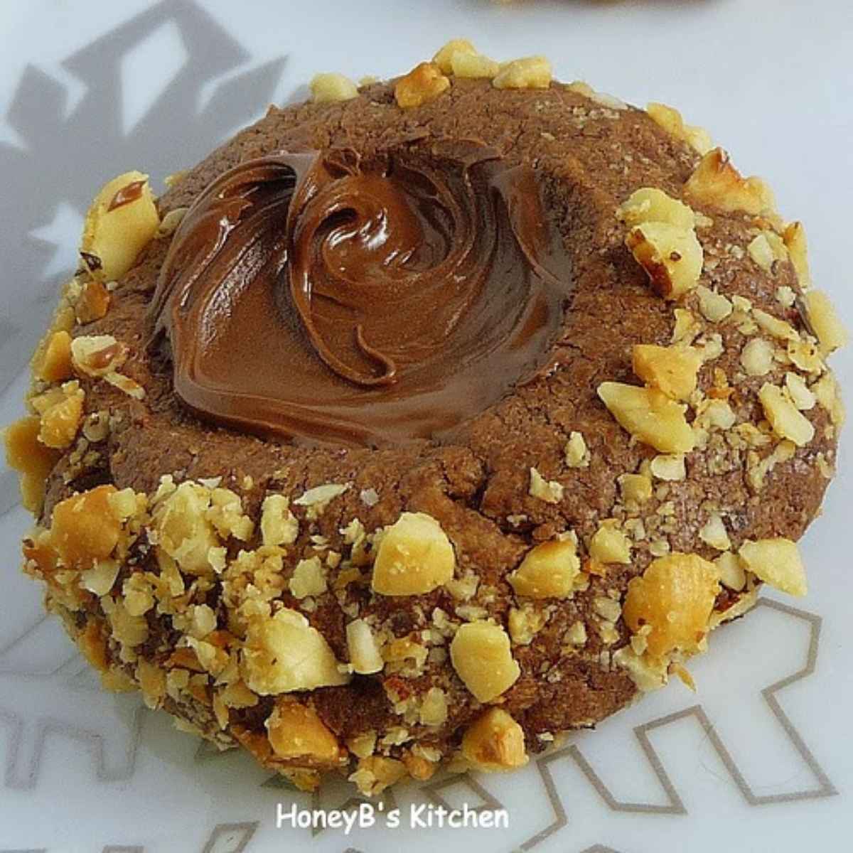 Upclose image of Chocolate Hazelnut Thumbprint Cookies on a snowflake plate
