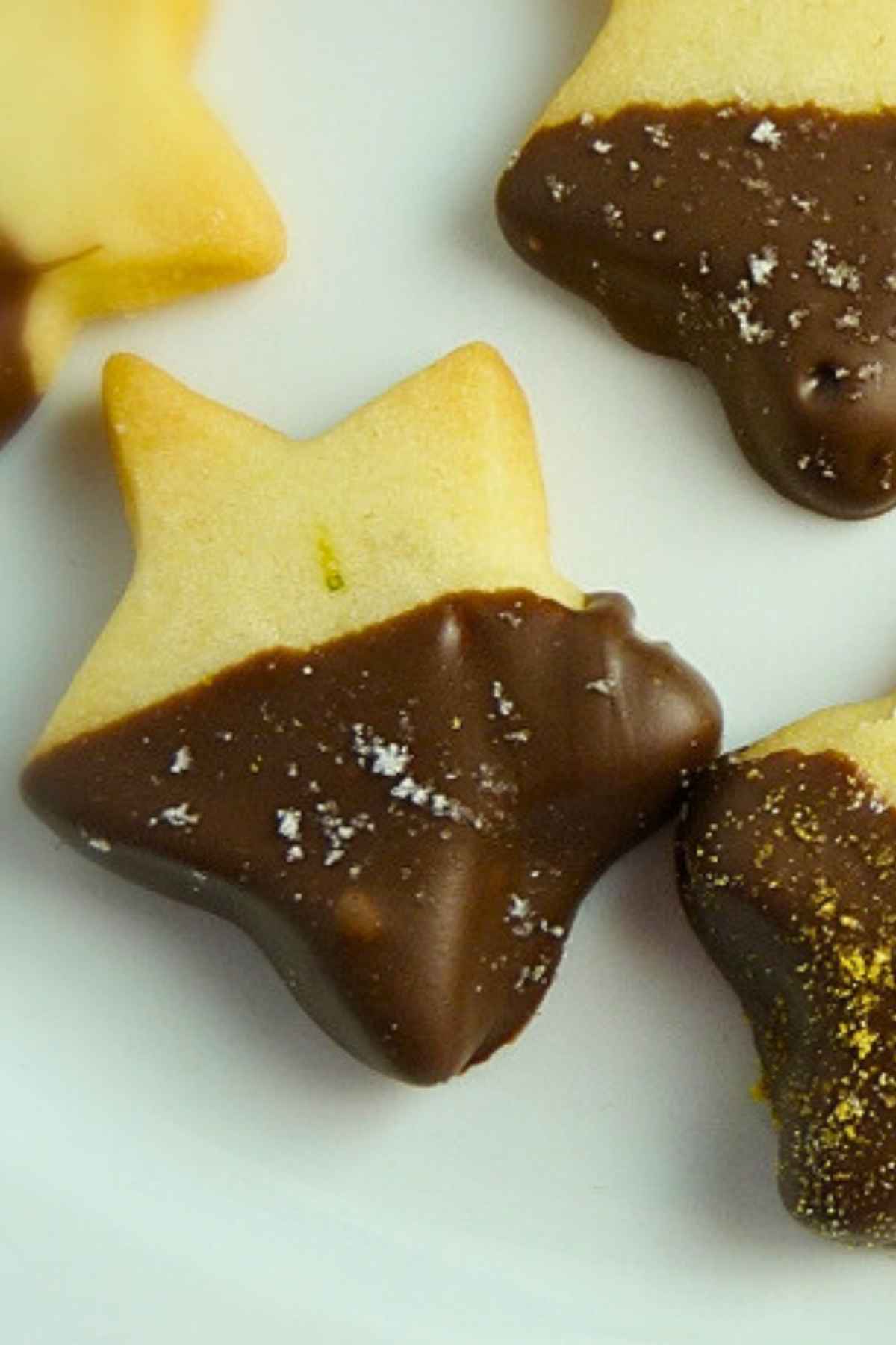 Shortbread cookies coated with milk chocolate and dusted with silver and gold dust.