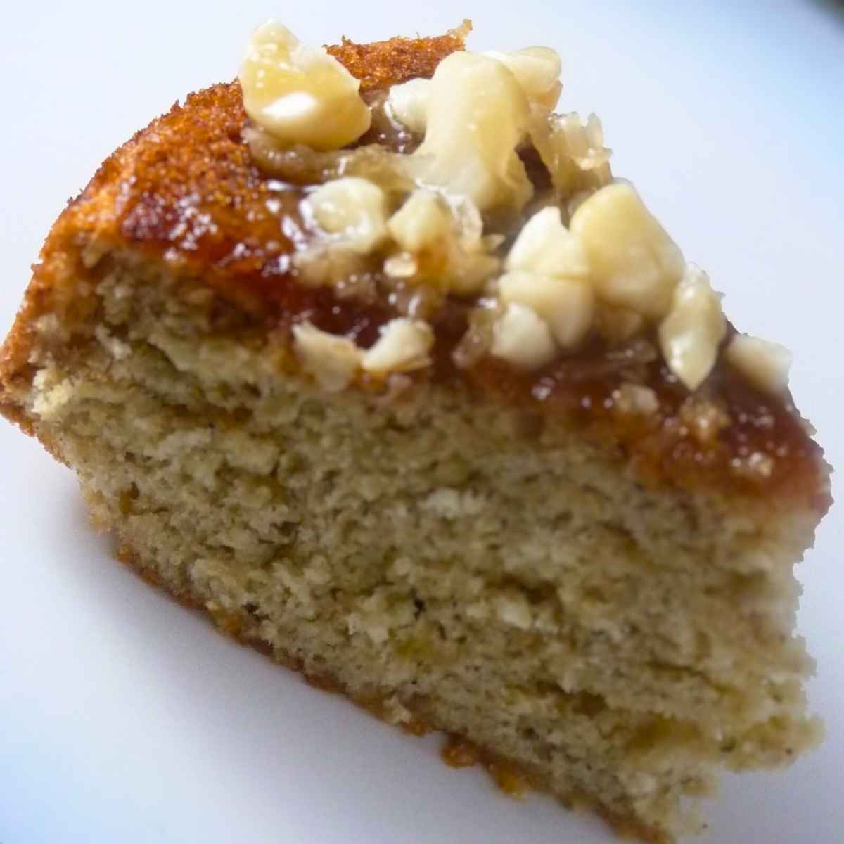 A slice of banana cake with a brown sugar macadamia topping.