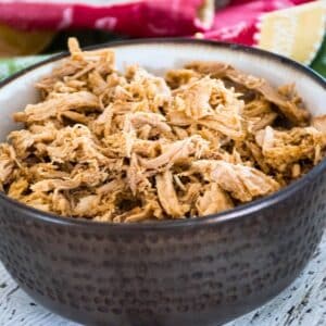 Instant Pot Pulled pork in a brown serving bowl.