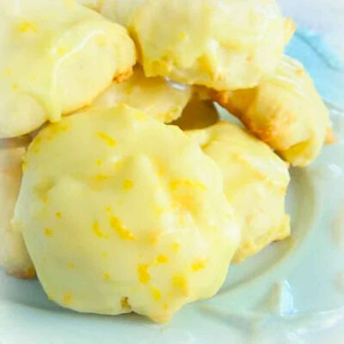 Uplclose image of orange glazed pineapple cookies on a blue plate.