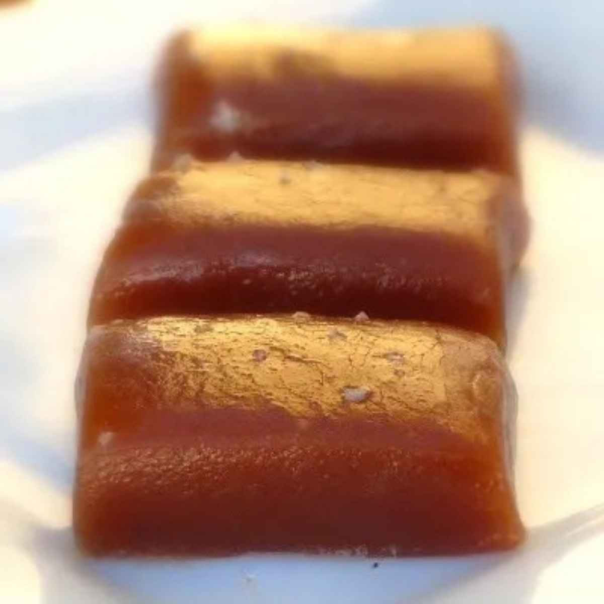 Soft and buttery fleur de sel caramels stacked together, ready to be wrapped in wax paper.