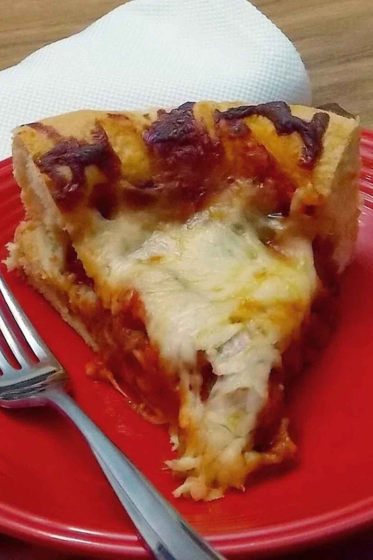 A generous slice of thick-crust Sausage Mushroom Onion Pizza with melted mozzarella cheese and savory toppings, served on a red plate with a fork.