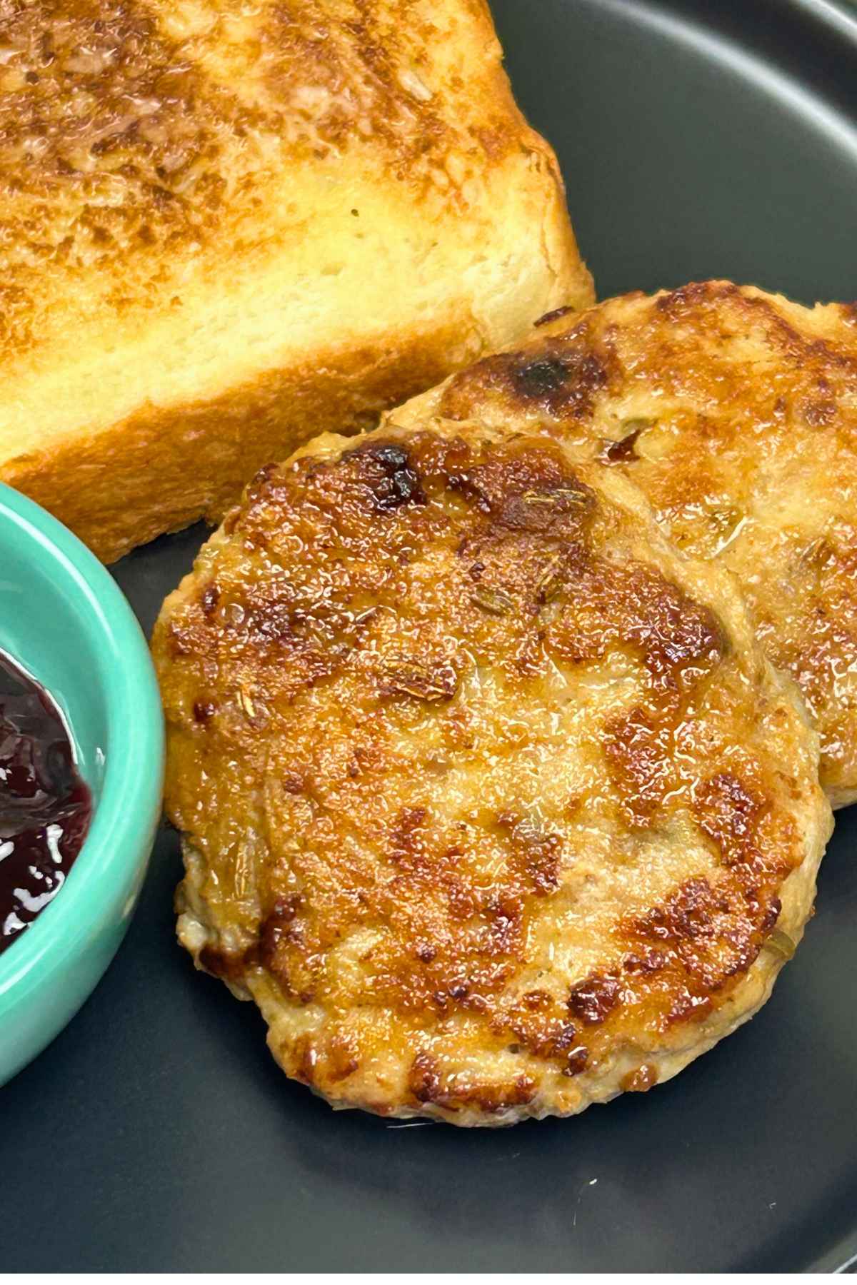 Homemade Chicken Breakfast Sausage patties golden-brown and crispy, served for breakfast with toast.