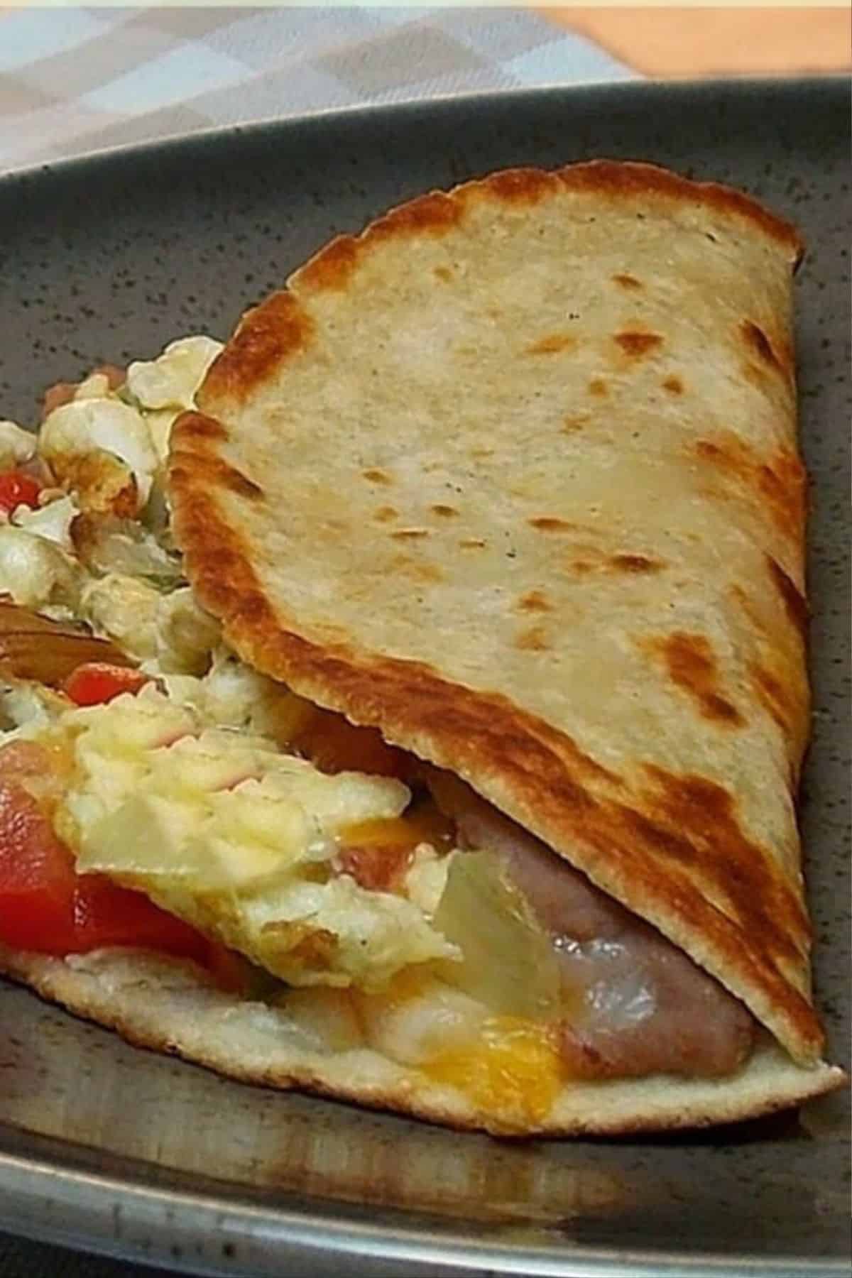Easy Breakfast Taco with scrambled eggs, melted cheese, and peppers in a toasted tortilla.