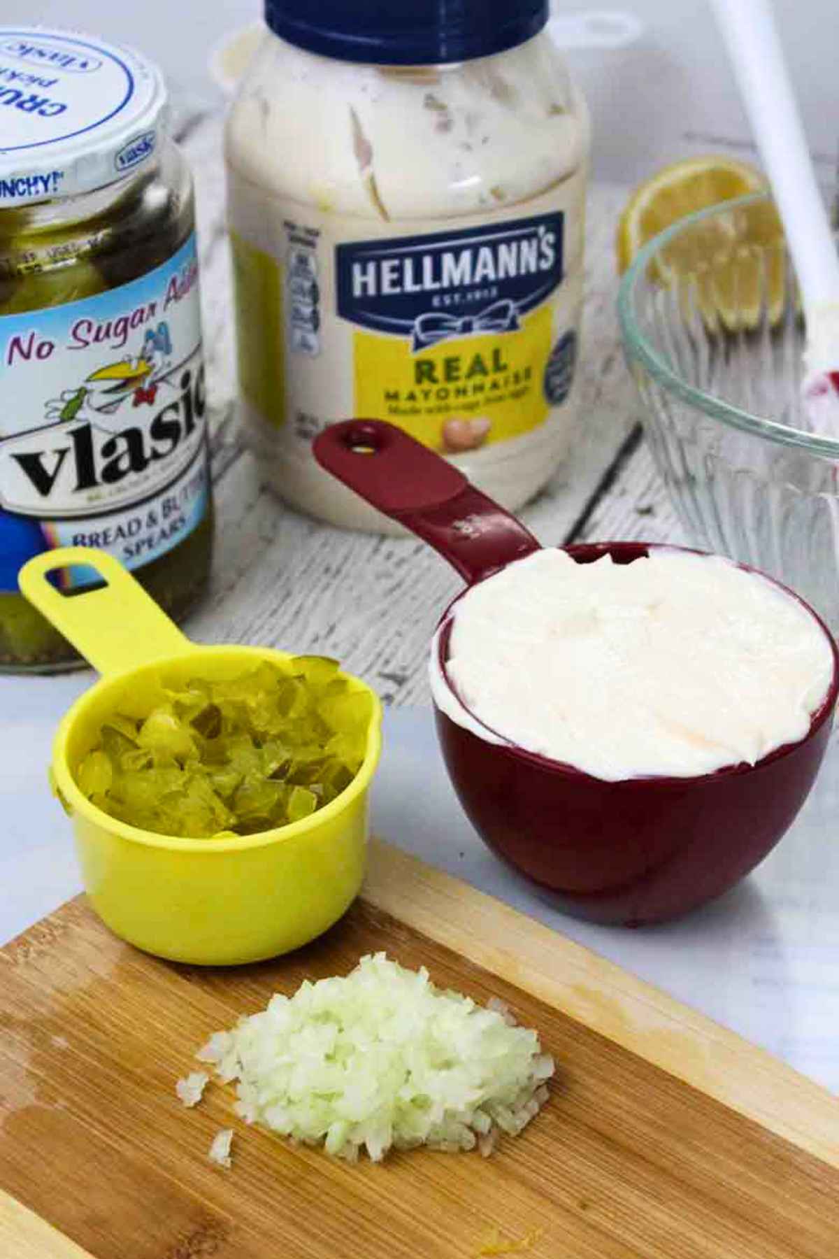 Ingredients for homemade tartar sauce featuring mayonnaise, Vlasic dill pickles, and minced onions.