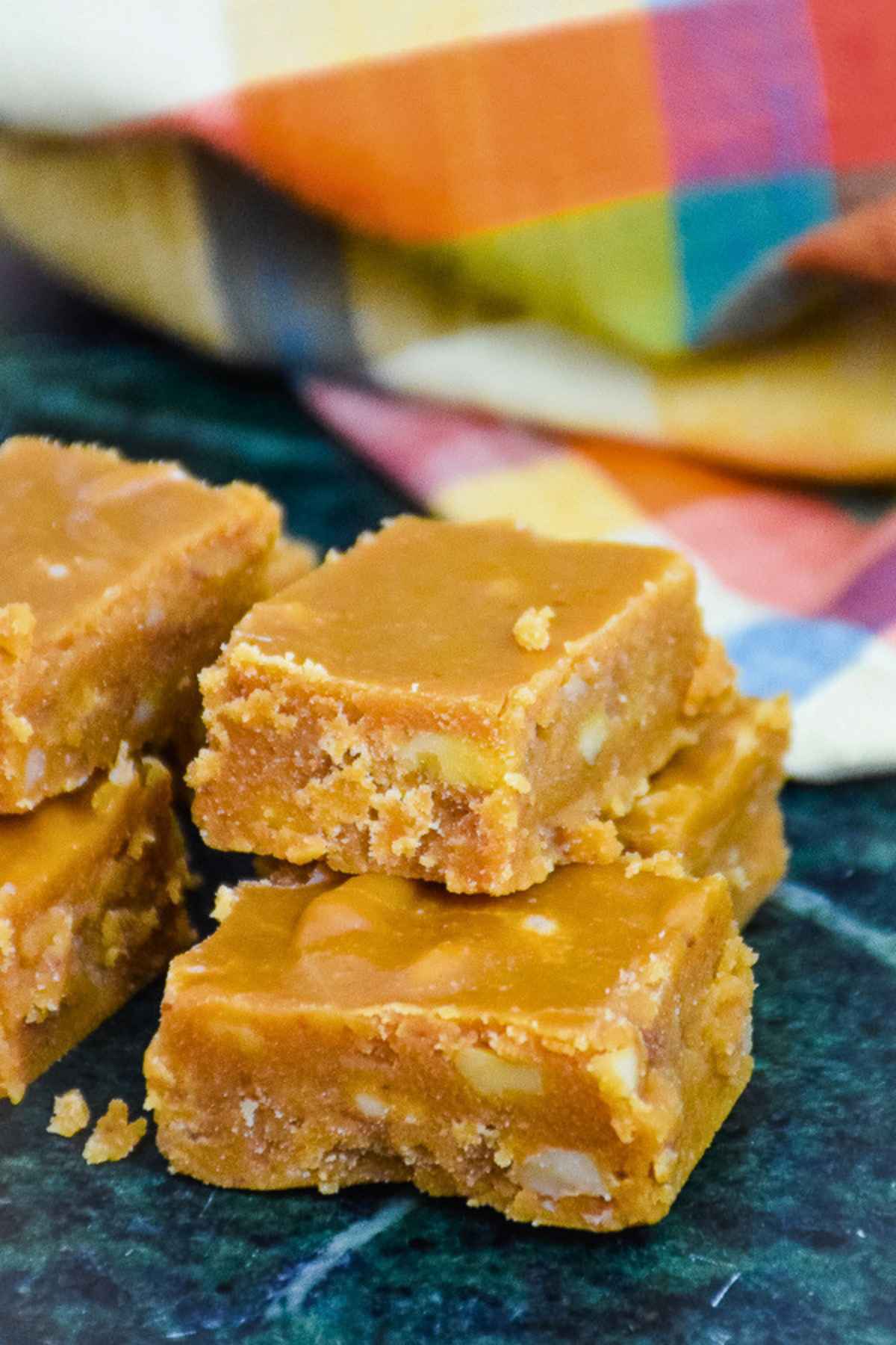 Stacked brown sugar fudge on a green marble board.