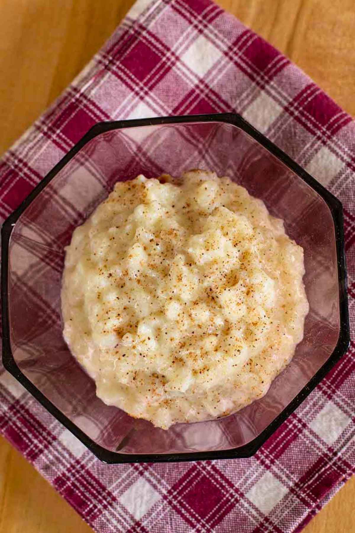 Old Fashioned Baked Rice Pudding in a vintage burgundy glass bowl.