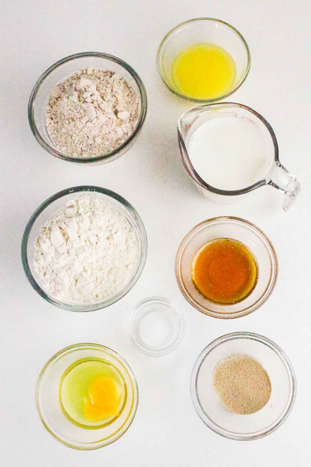 Bowls of baking ingredients arranged on a light background.