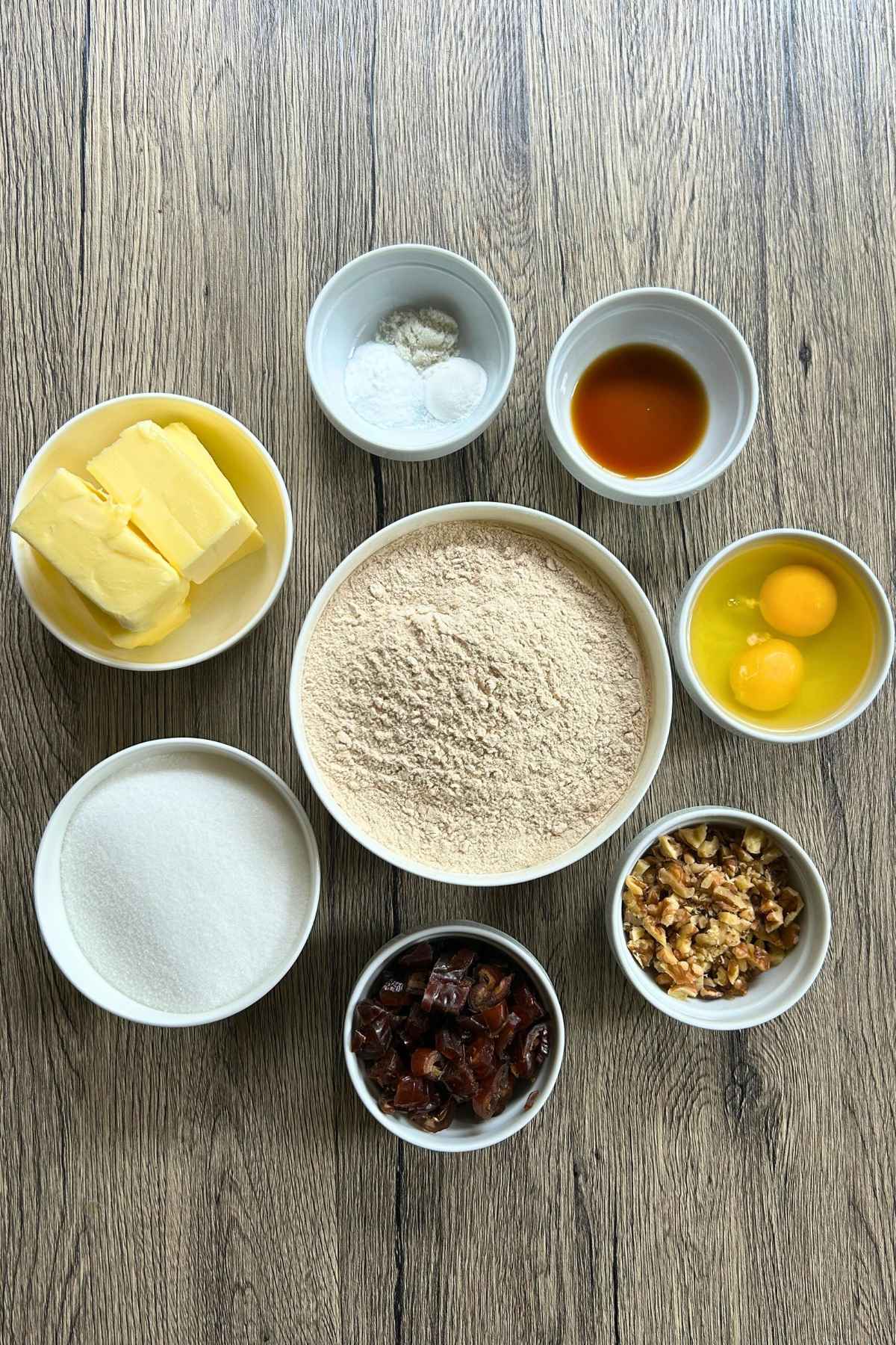 A view of baking ingredients in white prep bowls.