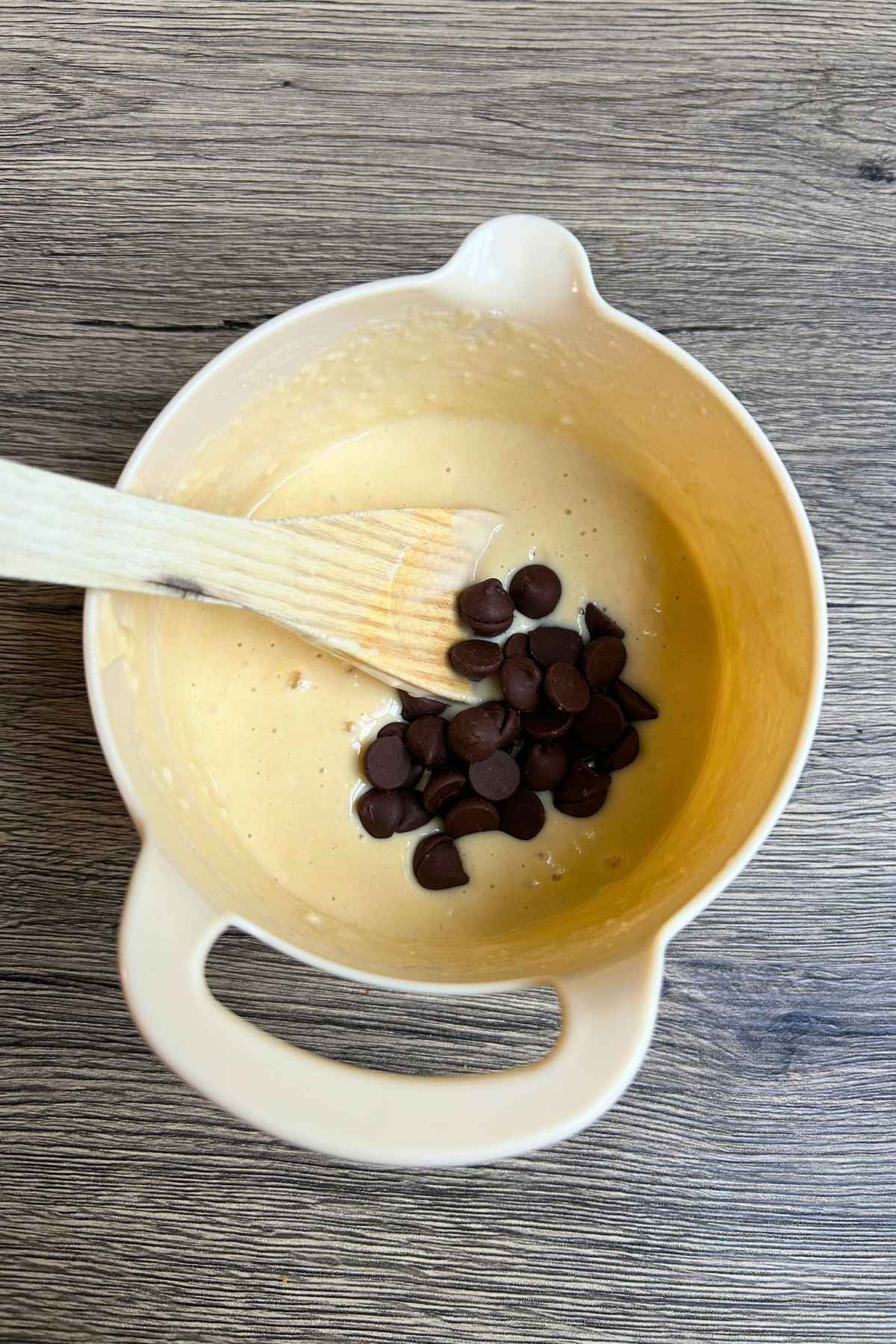Pancake batter with chocolate chips on top of the batter.